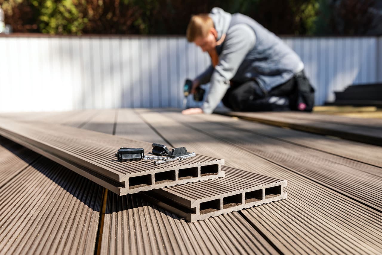 wpc terrace construction – worker installing wood plastic compos